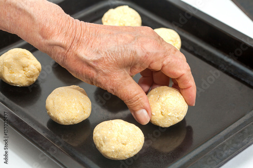 Pandebono preparation :  Placing raw pandebonos on a baking sheet photo