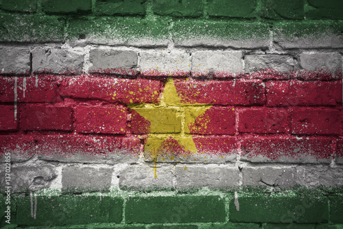 painted national flag of suriname on a brick wall