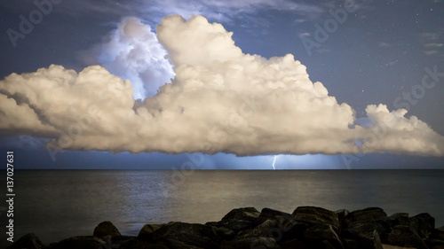 Nightime lightning strike from cloud into ocean