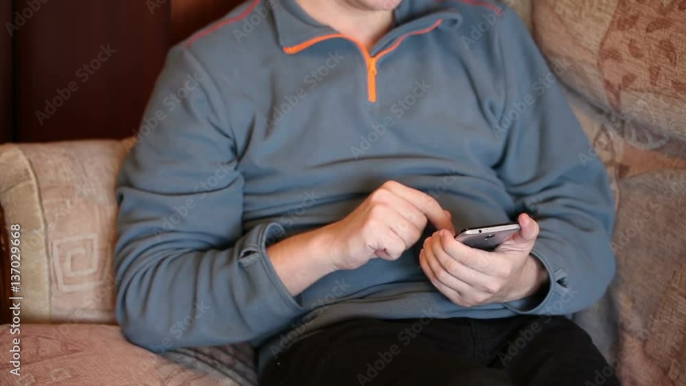 man using a smartphone. sitting on the couch. Close-up man using a smartphone. sitting on the couch. Close-up