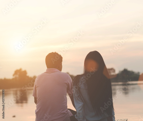 Romantic couple on the beach at colorful sunset on background © Janpen