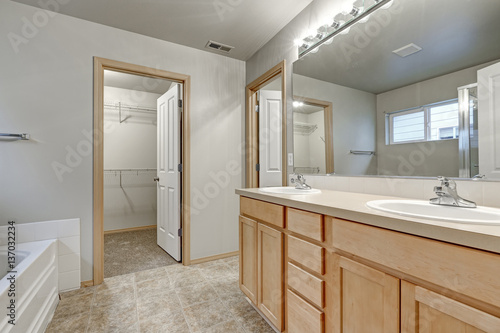 Grey bathroom interior with double sink wood vanity cabinet
