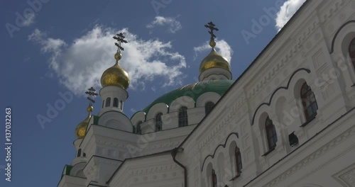 the Impressive View of the Monk Reflectory Belonging to Uspensky Sobor With Its Old Half Round Windows, Golden Domes and Picturesque Cloudscape photo