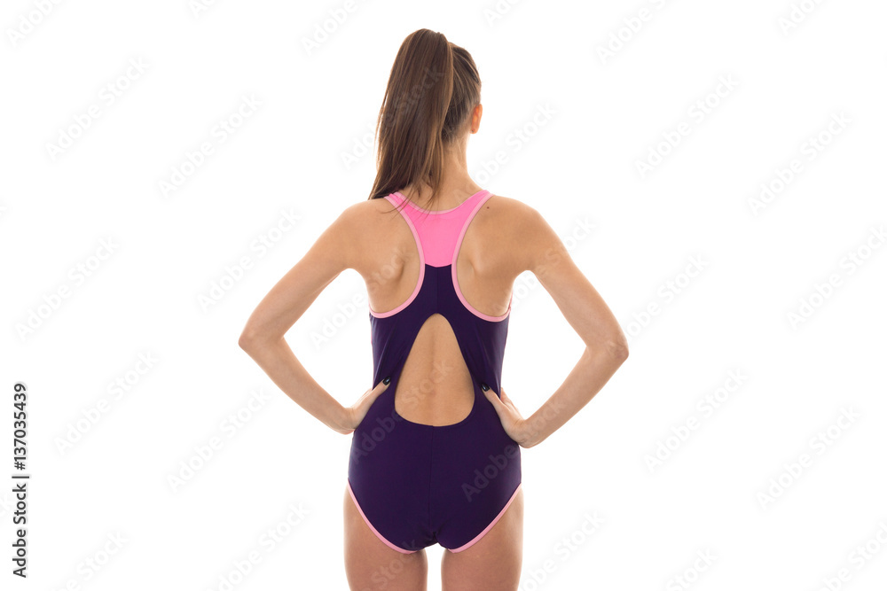 beautiful slim young brunette girl in body swimsuit with sexy round buttocks and hands on her hips from backside isolated on white background beautiful slim young brunette girl in body swimsuit with sexy round buttocks and hands on her hips from backside isolated on white background