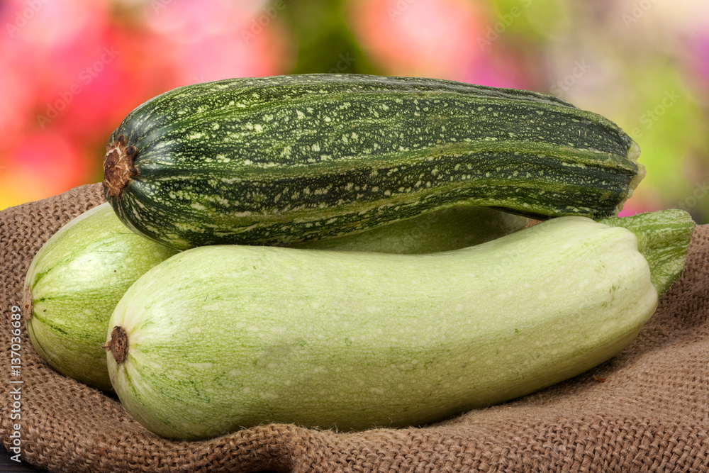 green zucchini and courgettes on sackcloth with a blurred background green zucchini and courgettes on sackcloth with a blurred background