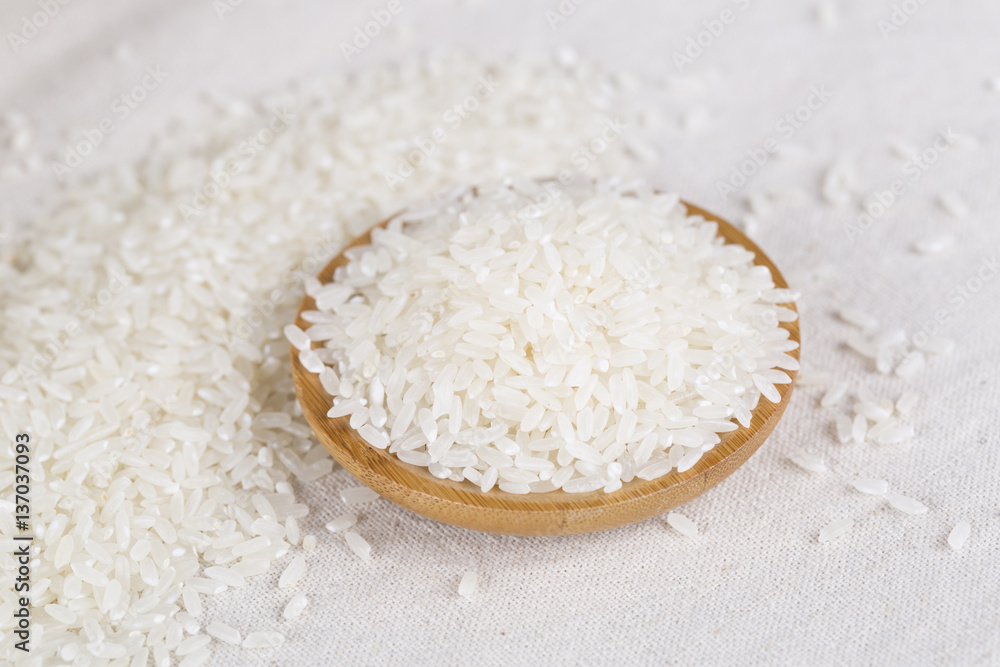 Rice grains closeup in a wooden bowl on a white background. Rice grains closeup in a wooden bowl on a white background.