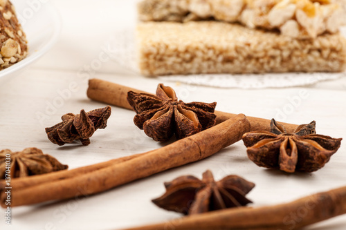 Cinnamon sticks with star anise on a white wooden table with sweet dessert on it