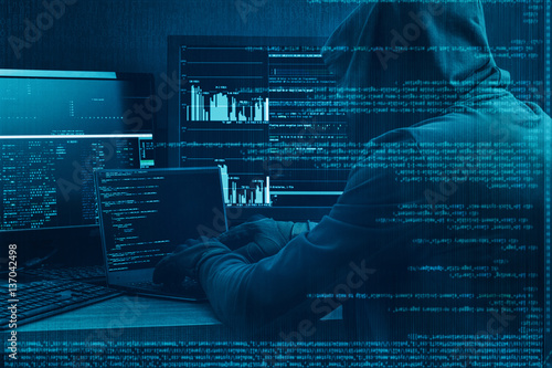 Internet crime concept. Hacker working on a code on dark digital background with digital interface around.