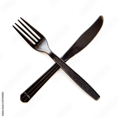 Black plastic crossed  fork and knife isolated