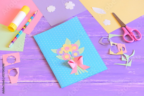 Creating a greeting card for mom. Step. Card with flowers made of colored paper. Materials for kids art on a wooden table. Gift idea for Mother's day, birthday, March 8 for preschool children to make