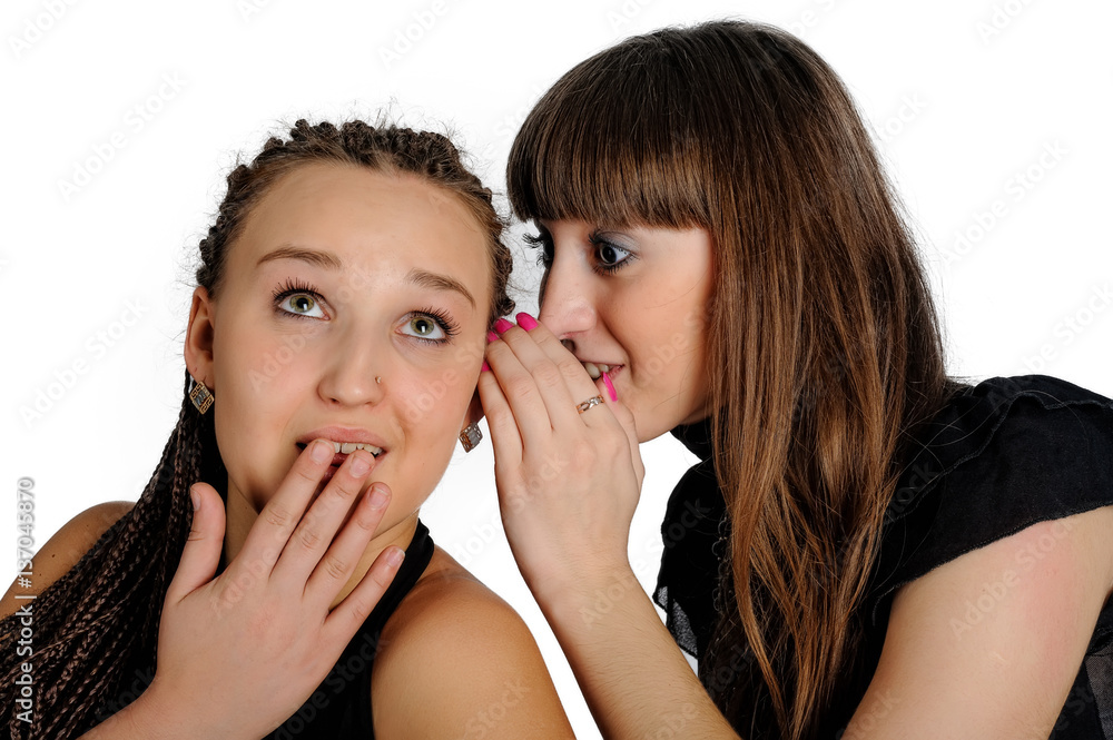 People, communication and friendship concept - smiling young women gossiping and whispering secrets People, communication and friendship concept - smiling young women gossiping and whispering secrets