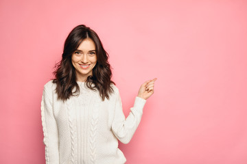 Cute young woman points a finger away