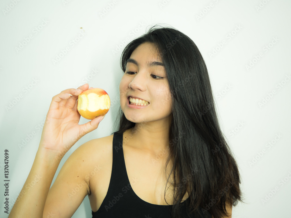 Asian woman eating red apple on white background Asian woman eating red apple on white background