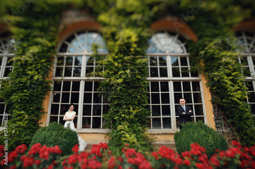 Elegant young couple near big beautiful windows of the castle