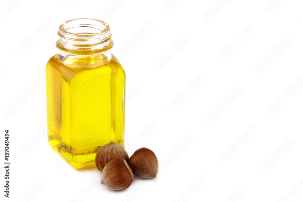 Hazelnut oil and hazelnuts on white background Hazelnut oil and hazelnuts on white background