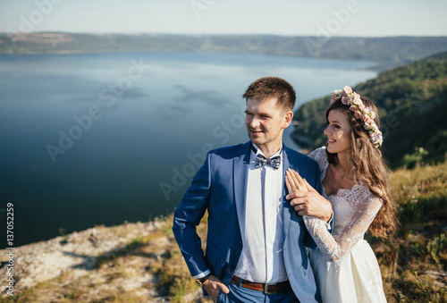 brides embace on the background of river