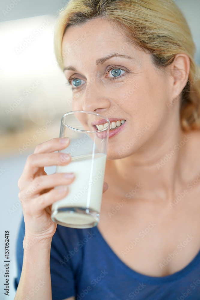 Portrait of blond mature woman drinking milk from glass Portrait of blond mature woman drinking milk from glass