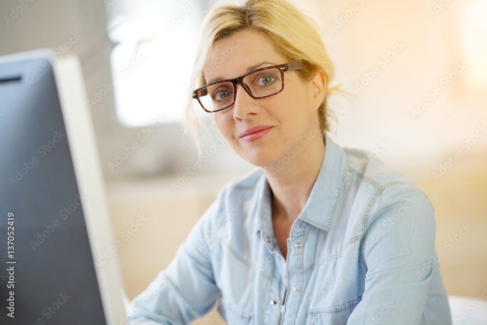 Portrait of woman in office working on desktop computer Portrait of woman in office working on desktop computer
