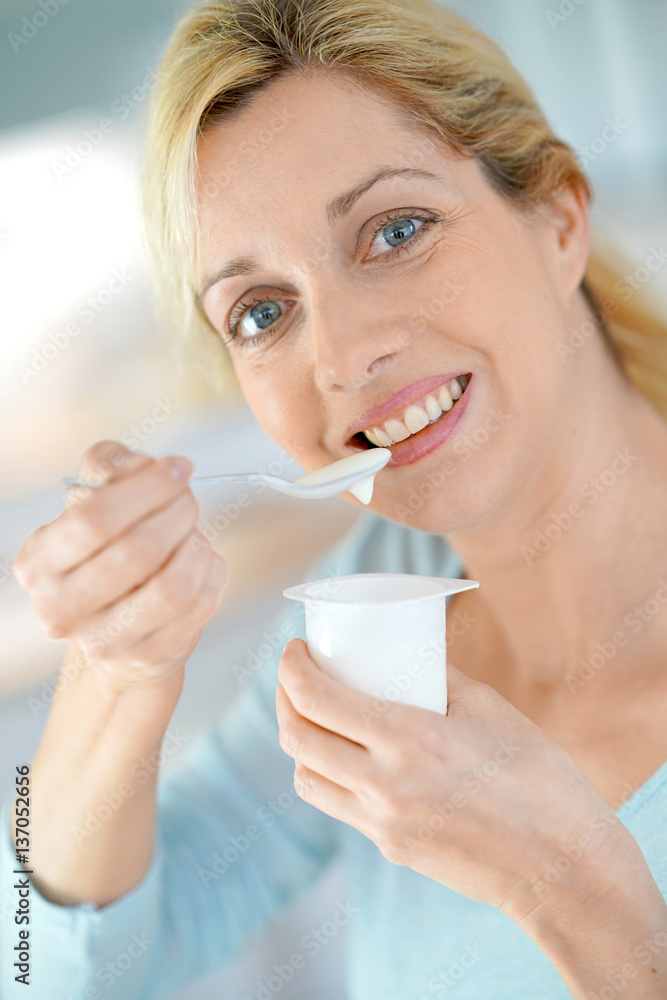 Portrait of blond woman eating yogurt Portrait of blond woman eating yogurt