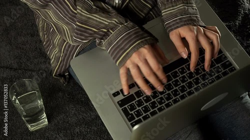 Close up of female hands using laptop sitting down on the floor at home