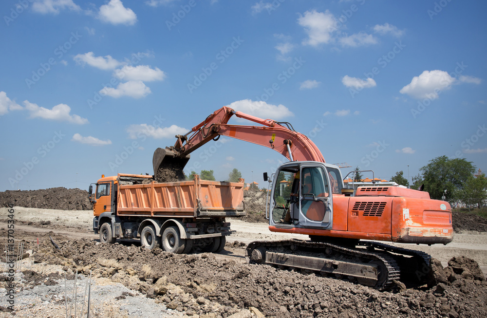 Excavator and truck working on road construction Excavator and truck working on road construction