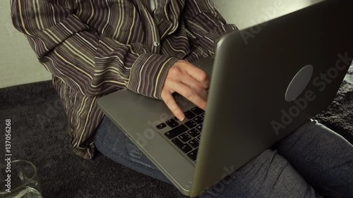 Close up of female hands using laptop sitting down on the floor at home