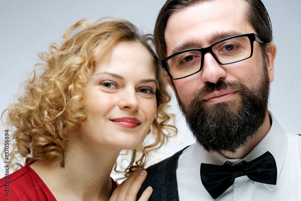 Portrait of young couple in love posing at studio dressed in classic clothes Portrait of young couple in love posing at studio dressed in classic clothes