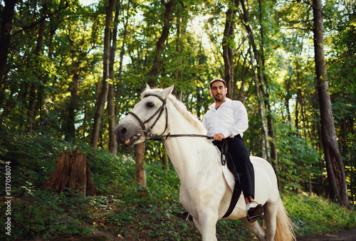 The seriously groom riding a horse © myronovychoksana