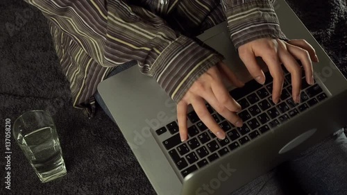 Close up of female hands using laptop sitting down on the floor at home, slow motion