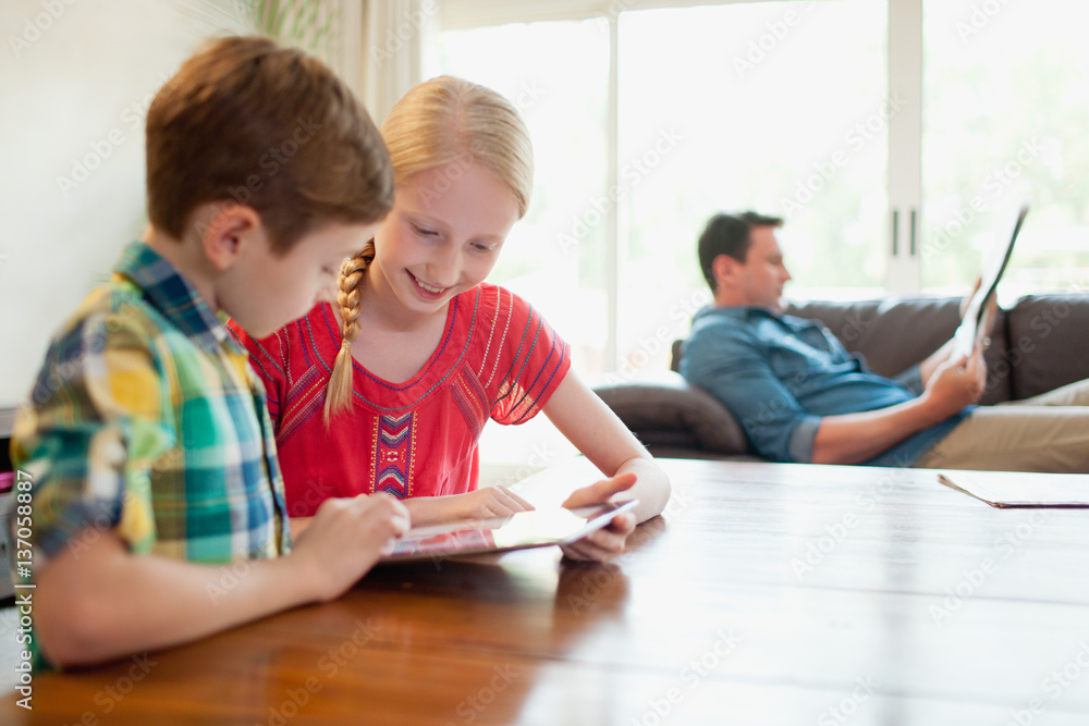 Father with children using digital tablet at home. Father with children using digital tablet at home.