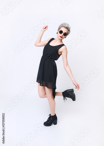 Sexy Blonde Woman balancing on leg in Little Black Dress