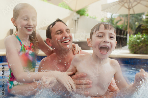 Father with children having fun in swimming pool. photo