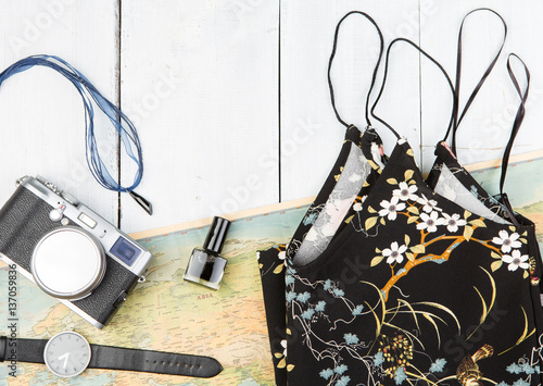 map, watch, camera on white wooden table