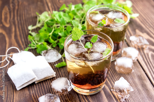 Ice tea with berry and fresh mint in glasses Wooden background