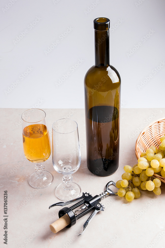 Obraz premium White wine and grapes. White wine in glass, bottle, corkscrew an