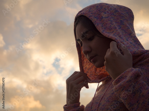 Asian woman wearing hood, sutset sky background photo