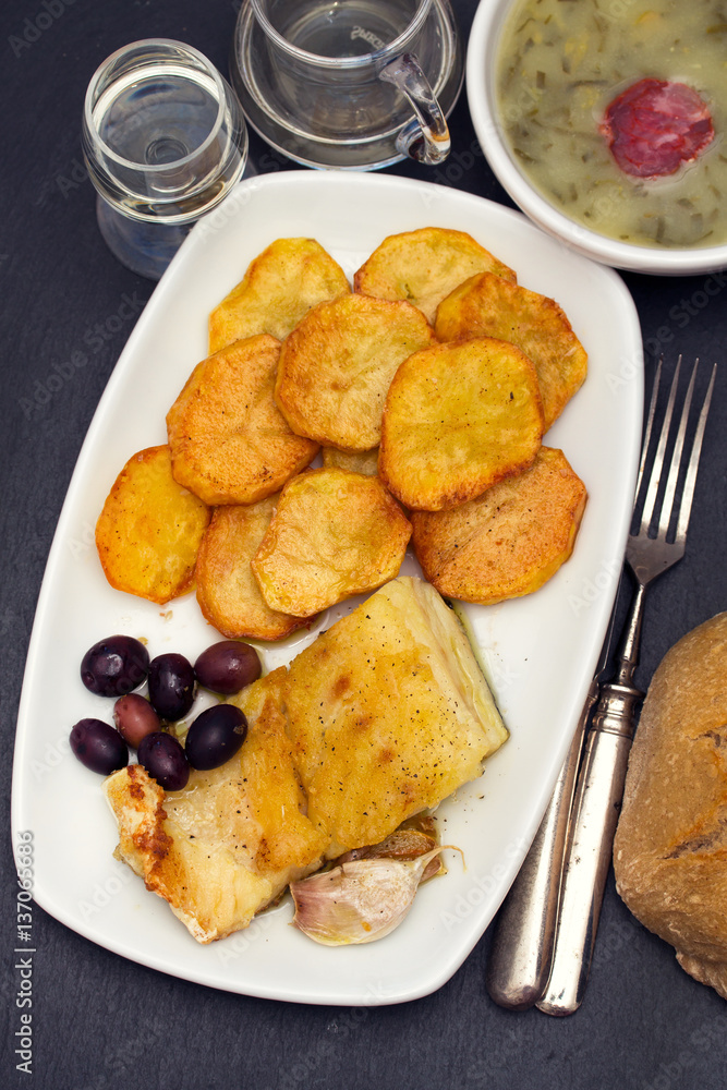 fried cod fish with potato on white dish