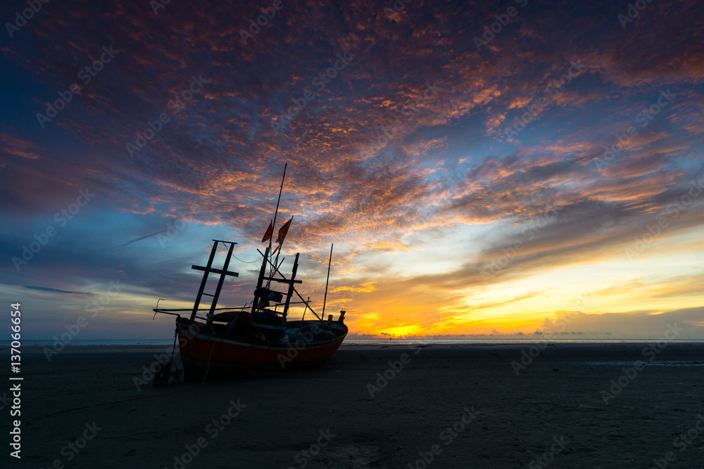 fishing boat on the beach with beautiful clouds in the morning