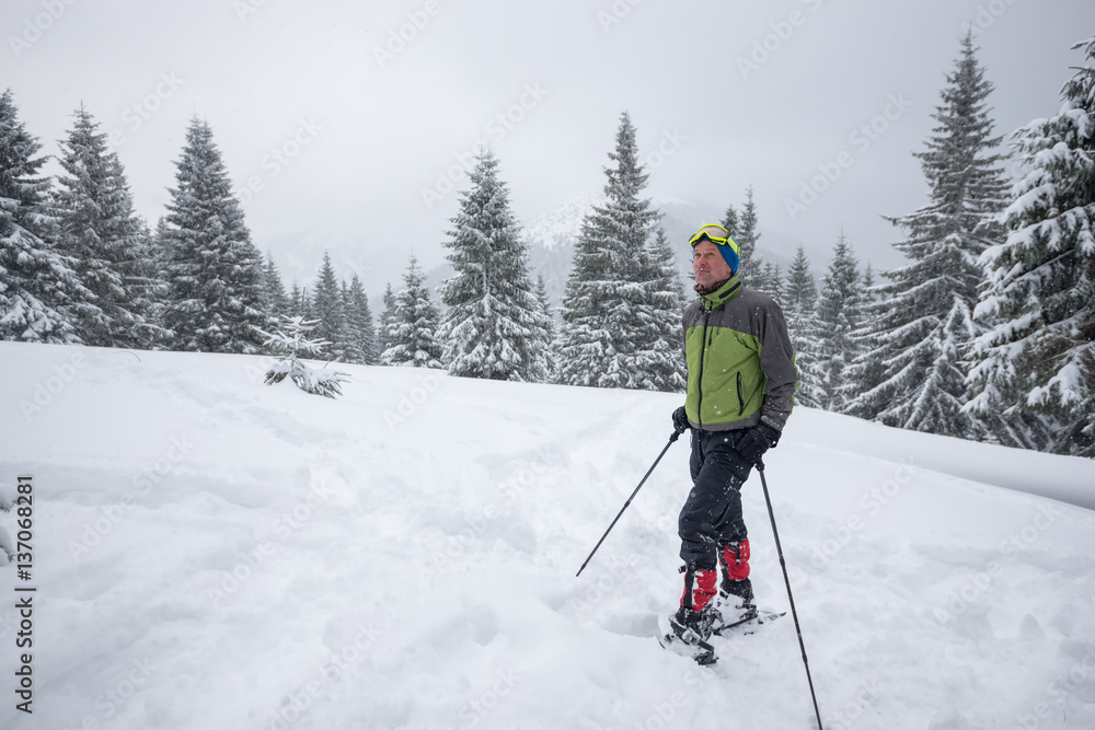 Traveler in snowshoes is resting after an hard way Traveler in snowshoes is resting after an hard way