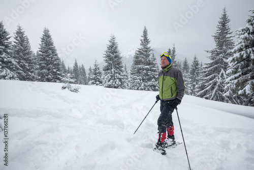 Traveler in snowshoes is resting after an hard way