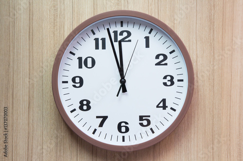 brown and white clock shown almost mid day or mid night time on