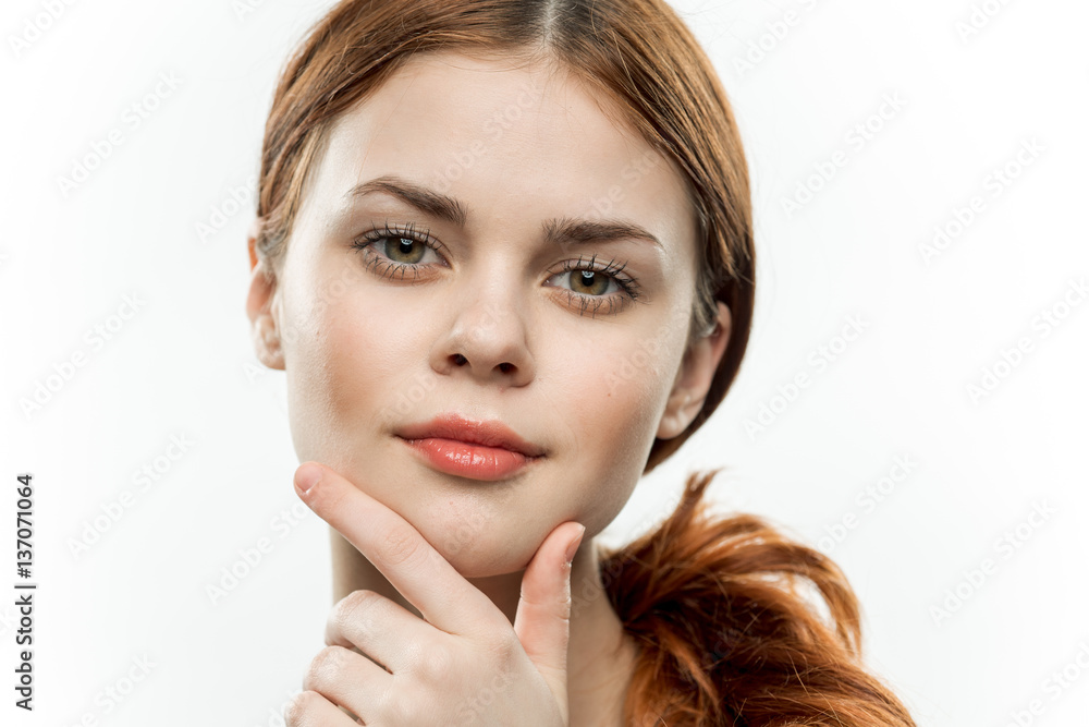 pretty red-haired woman holding her hand on her chin pretty red-haired woman holding her hand on her chin