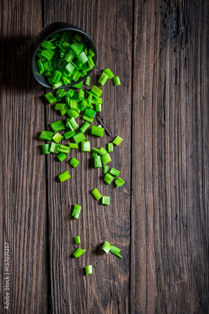 Fresh chopped chives in small bowl on wooden table Fresh chopped chives in small bowl on wooden table