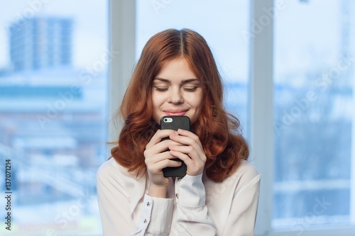 happy woman with phone in office © SHOTPRIME STUDIO