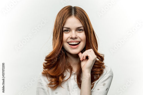 cheerful red-haired woman on a light background