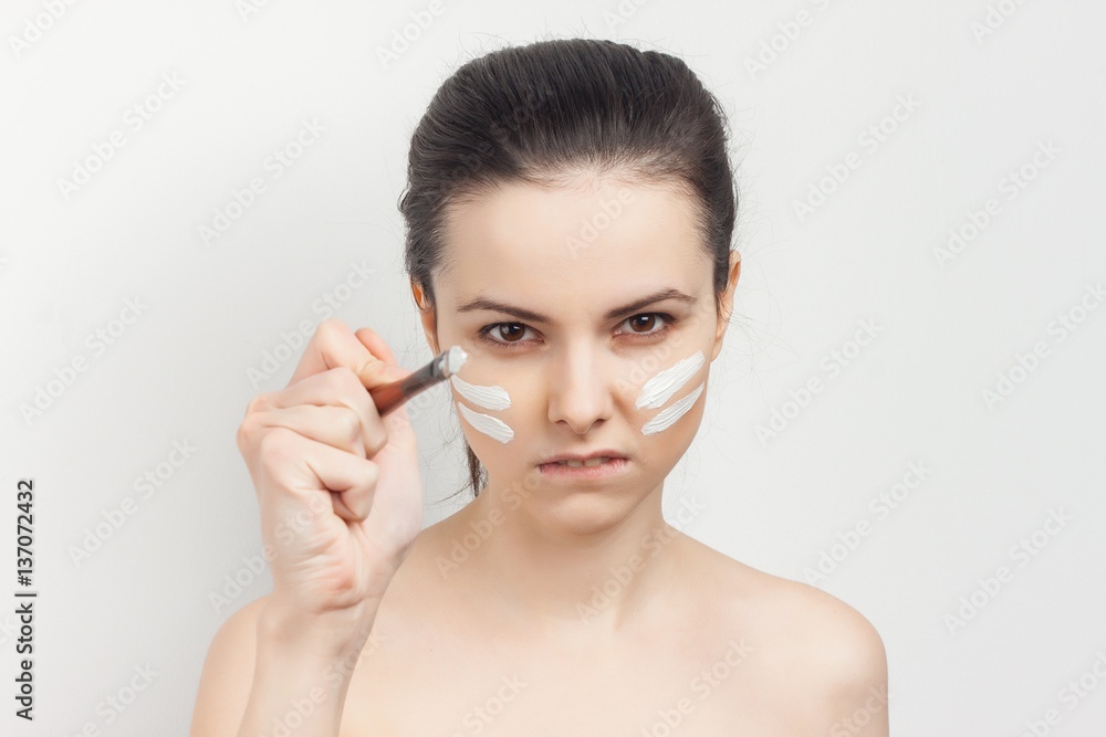 a woman paints herself with a face cream brush a woman paints herself with a face cream brush
