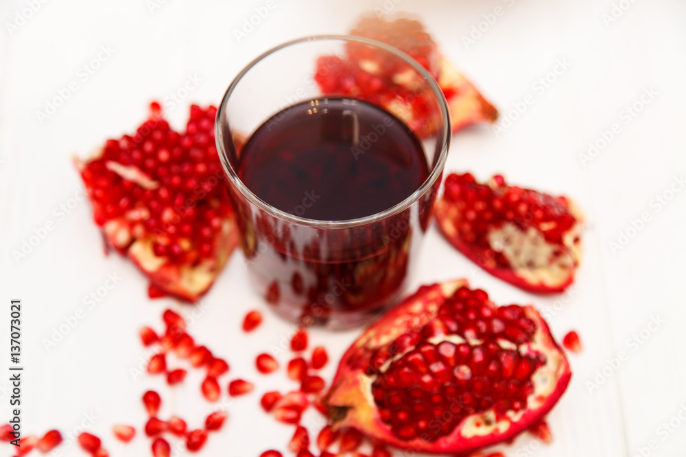 A glass of pomegranate juice and pomegranate seeds A glass of pomegranate juice and pomegranate seeds