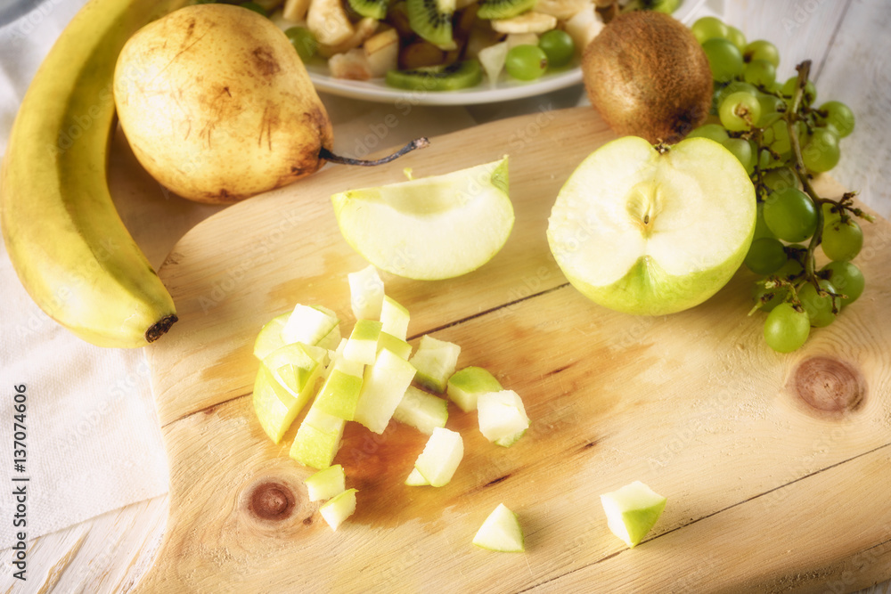 Ingredients for fruit salad. Cutting apple Ingredients for fruit salad. Cutting apple