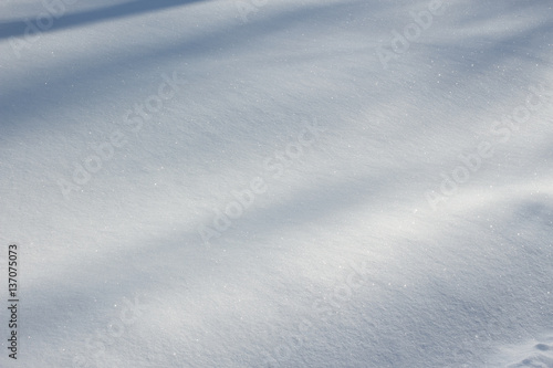 Fresh snow texture with natural shadows on winter ground. Horizontal color image of beautiful white nature background of snowy clean surface. © Andrii Oleksiienko