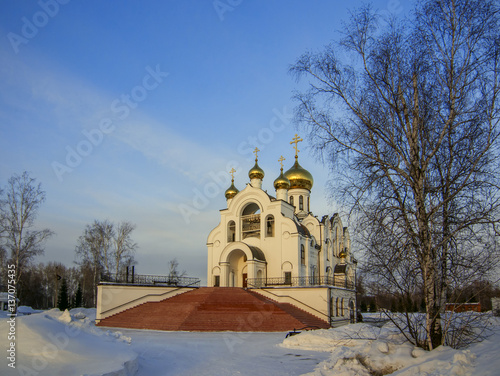 Obraz na płótnie Cathedral in snow under blue sky and birches w salonie